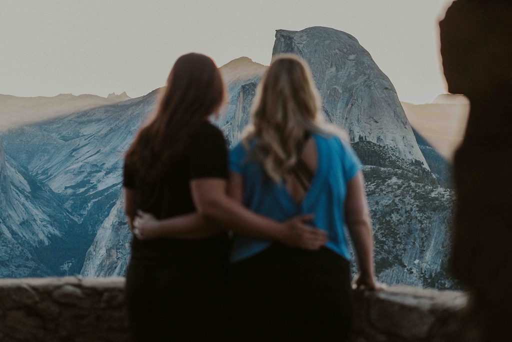 Couple standing in front of half dome during a glacier point proposal 